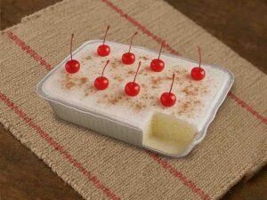Postre tres leches artesanal con canela y cerezas rojas sobre mantel rústico